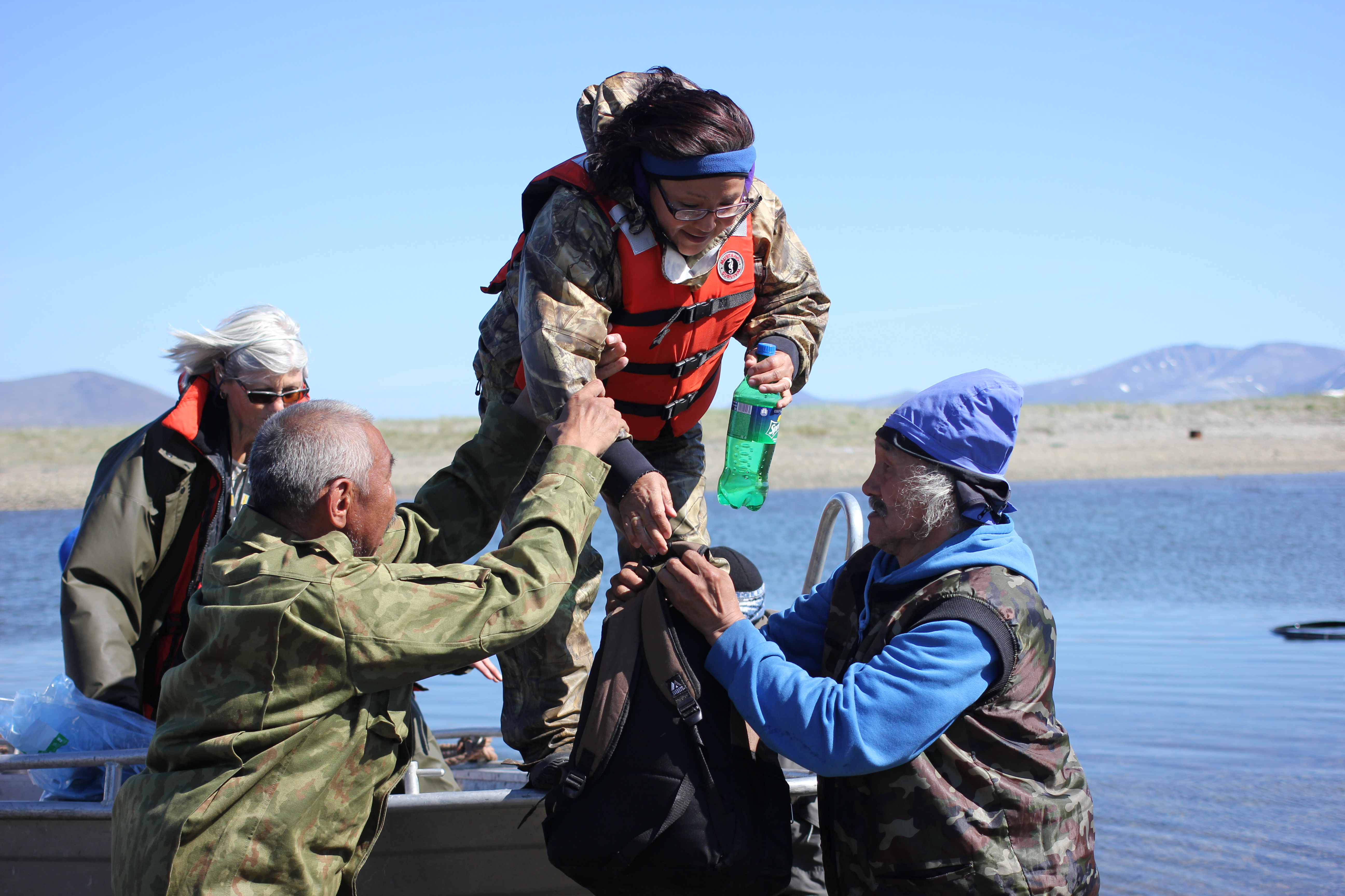 Chukchi men help Etta Tall disembark the boat at Senyavin Hot Springs, part of Chukotka’s Beringia National Park. The Diomede Island Family Reunion expedition relied on help from local hunters throughout the course of the July 2016 trip. (Kirsten Swann / Alaska Dispatch News)