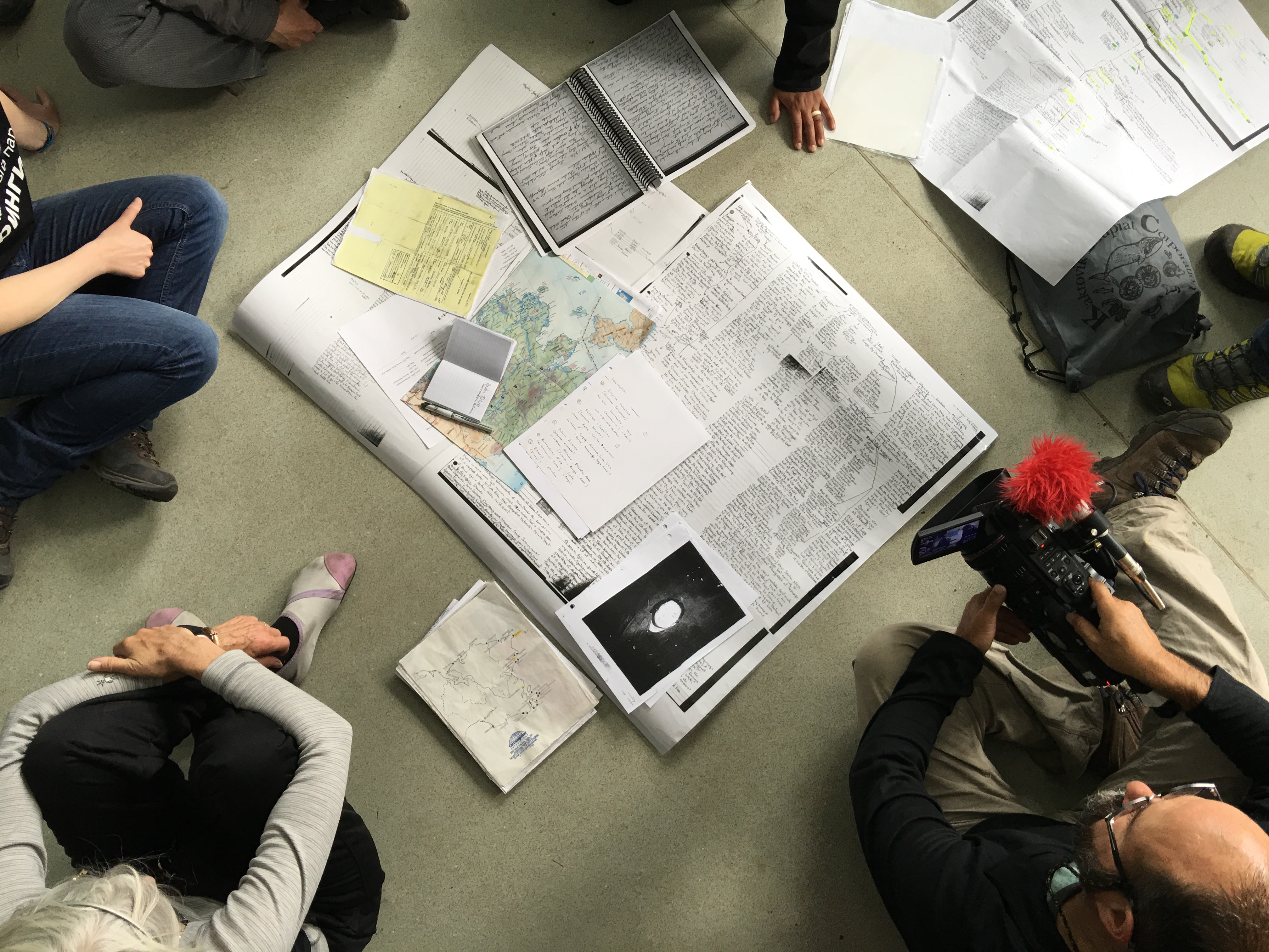 Members of the Diomede Island Family Reunion expedition examine an old family tree and other historical documents on the floor of the ivory carving school in Uelen, Chukotka, July 2016. (Kirsten Swann / Alaska Dispatch News)