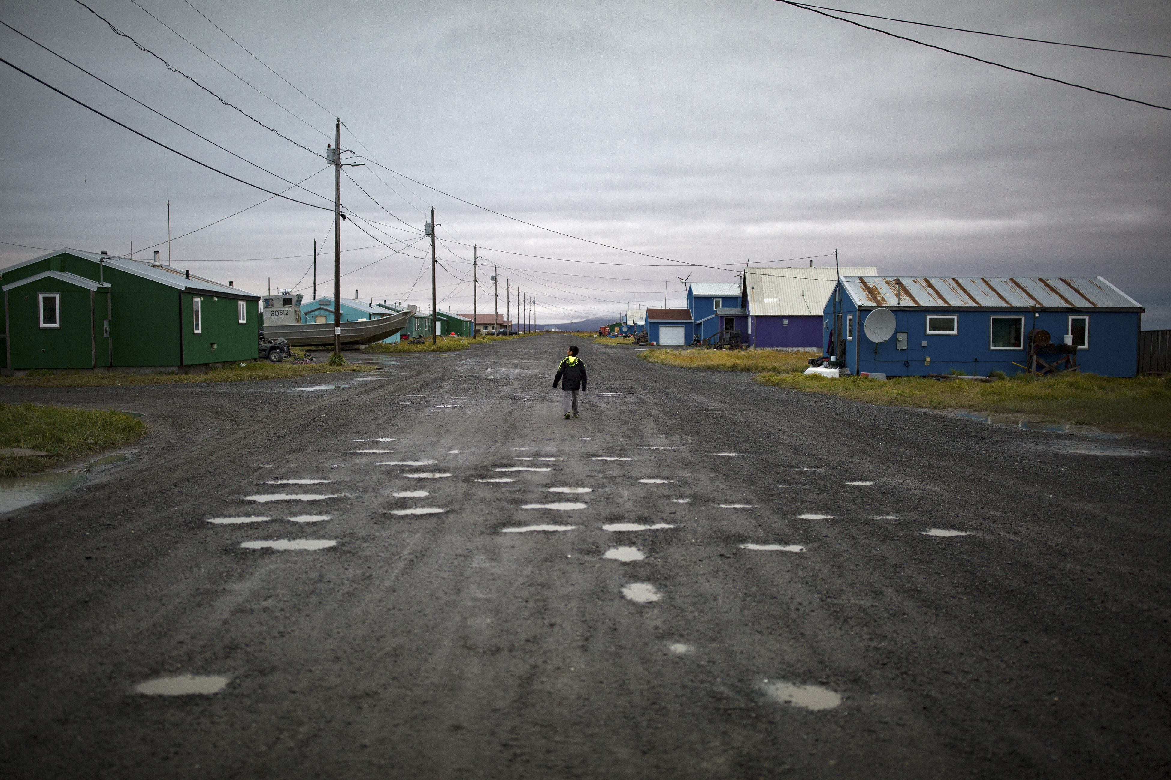 A road full of potholes and puddles in the Alaskan village of Shaktoolik, Sept. 15, 2016. The government has identified at least 31 Alaskan towns and cities at imminent risk of destruction from flooding and erosion due to the changing climate, with Shaktoolik ranking among the top four. (Josh Haner/The New York Times)