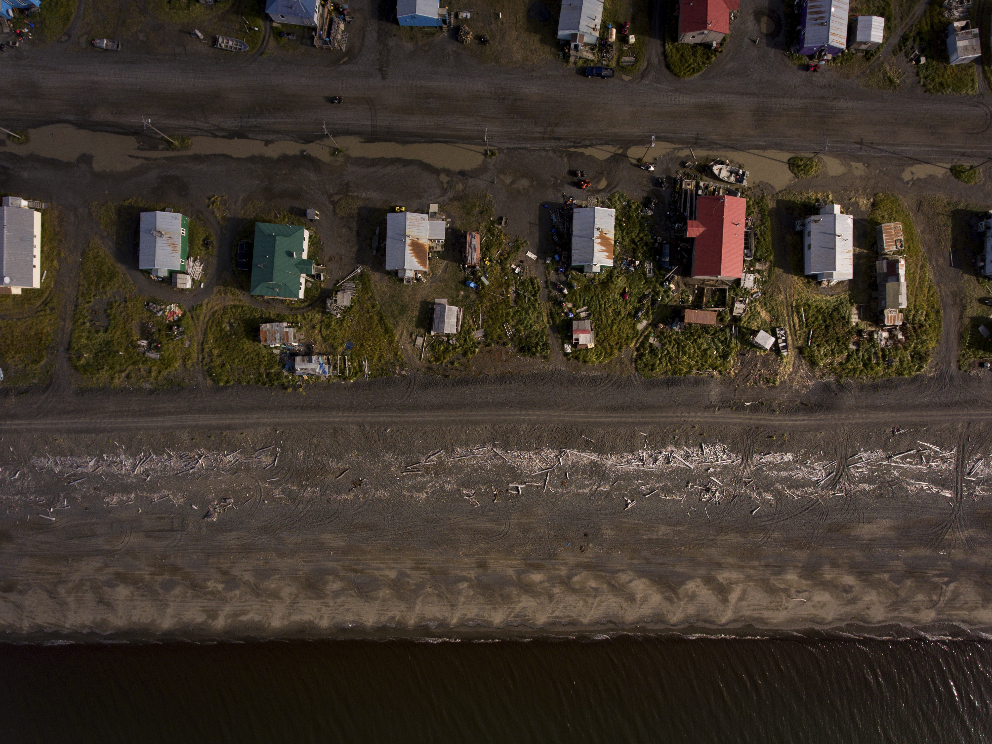 An aerial bird's eye view of homes on the ocean's edge in the Alaskan village of Shaktoolik, Sept. 17, 2016. Laid out on a narrow spit of sand between the Tagoomenik River and the Bering Sea, the village is facing an imminent threat from increased flooding and erosion, signs of a changing climate. (Josh Haner/The New York Times)