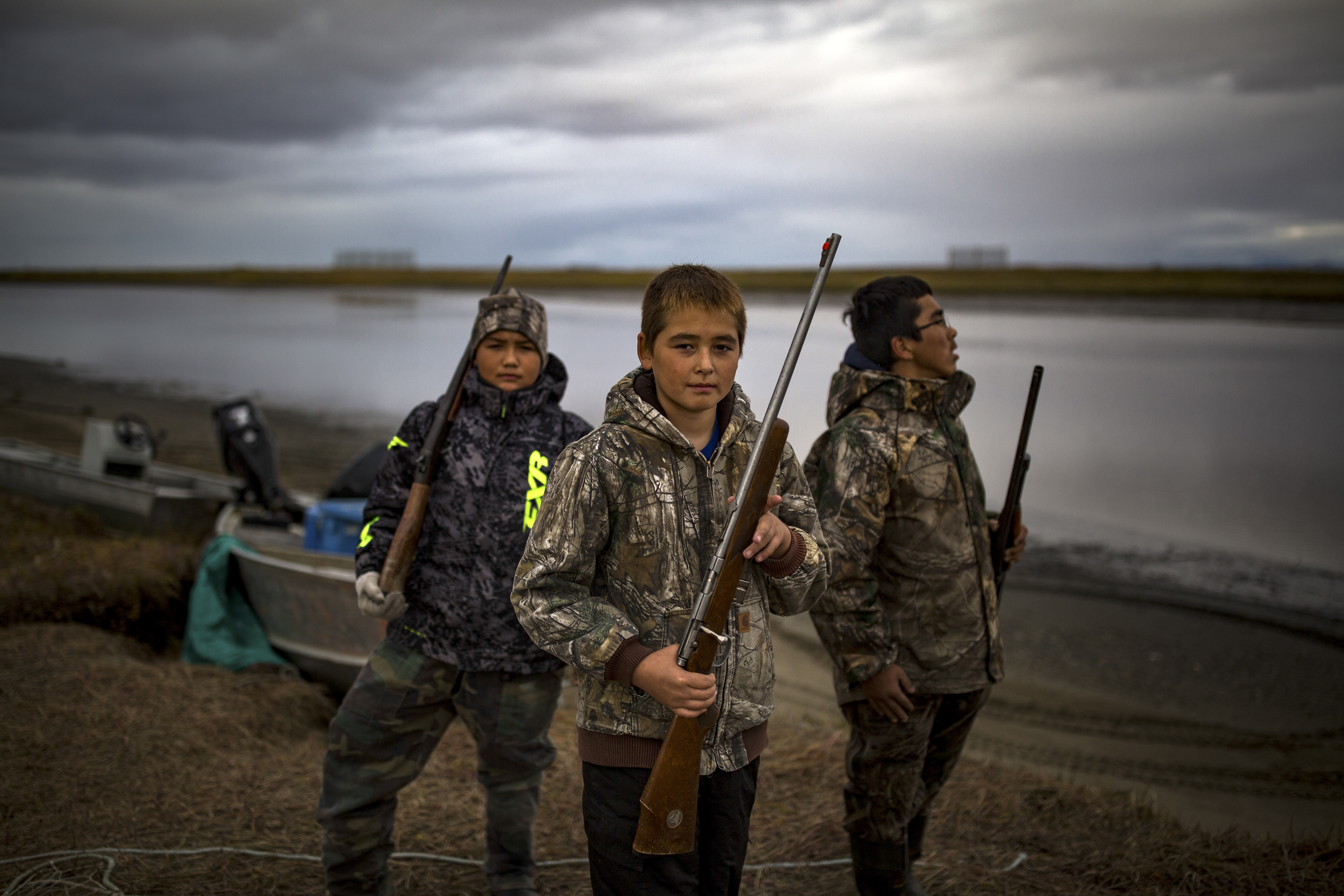 From left: Skyler Jones, 12, Keenan Jackson, 11, and Taylor Kulukhon, 14, head out to hunt, in the Alaskan village of Shaktoolik, Sept. 17, 2016. Laid out on a narrow spit of sand between the Tagoomenik River and the Bering Sea, the village is facing an imminent threat from increased flooding and erosion, signs of a changing climate. (Josh Haner/The New York Times)