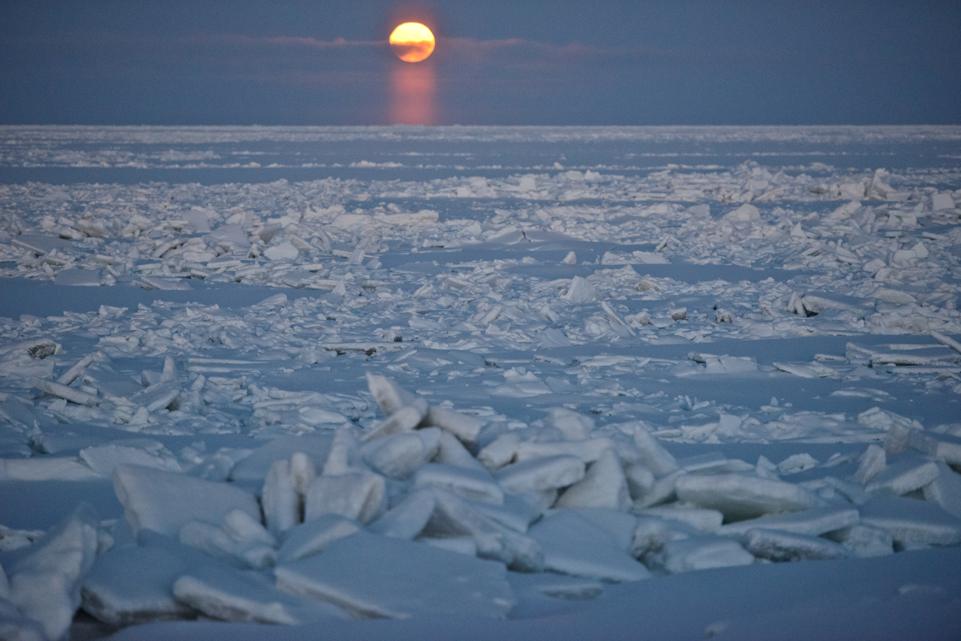 The moon is visible over ice offshore from a road a few miles northeast of Utqiagvik on Tuesday, December 13, 2016. (Marc Lester / Alaska Dispatch News)