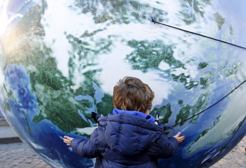 A child embraces a globe shaped balloon ahead of the start of the 2015 Paris World Climate Change Conference, known as the COP21 summit, in Rome, Italy , November 29, 2015. REUTERS/Alessandro Bianchi