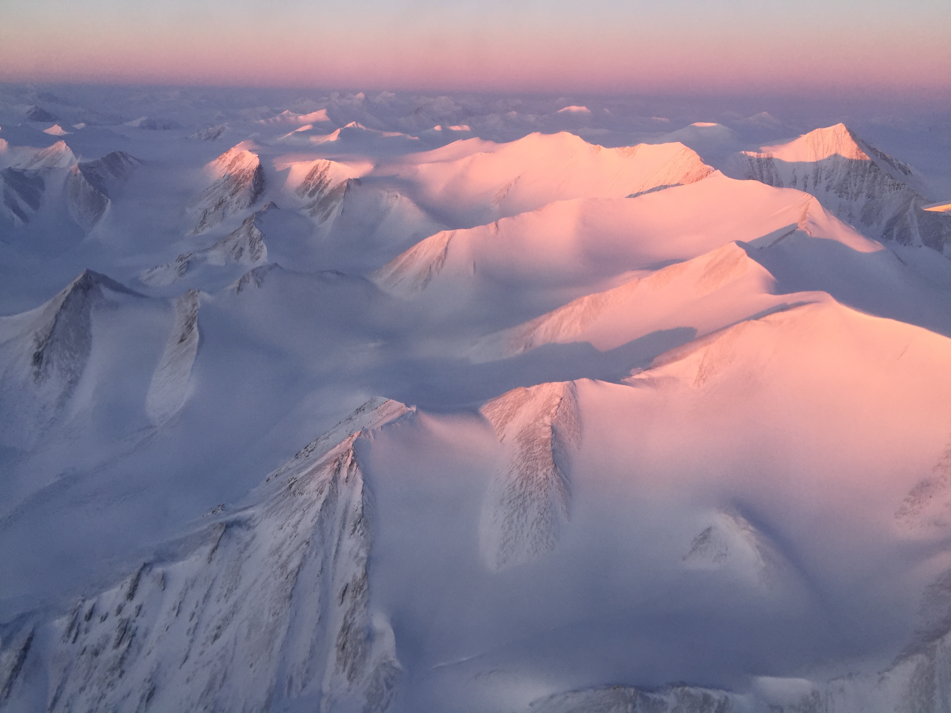 Ellesmere Island mountain tops bathed in light as the sun began to peak over the horizon during Operation IceBridge’s first flight of its 2017 Arctic campaign, on March 9, 2017. (Nathan Kurtz / NASA)