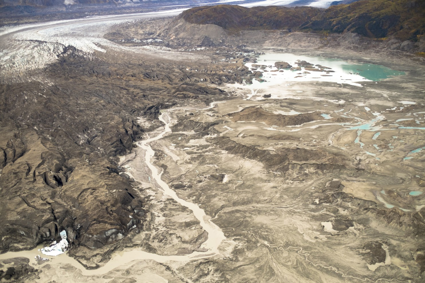 A stream runs along the toe of Kaskawulsh glacier in Canada. In 2016, this channel allowed the glacier's meltwater to drain in a different direction than normal, resulting in the Slims River water being rerouted to a different river system. MUST CREDIT: Dan Shugar.
