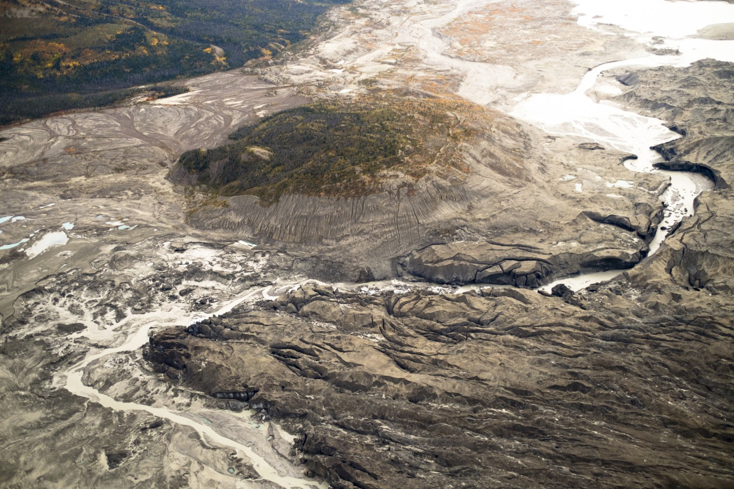 A stream flows through the toe of Kaskawulsh glacier in Canada. In 2016, this channel allowed the glacier’s meltwater to drain in a different direction than normal, resulting in the Slims River water being rerouted to a different river system. MUST (Dan Shugar)