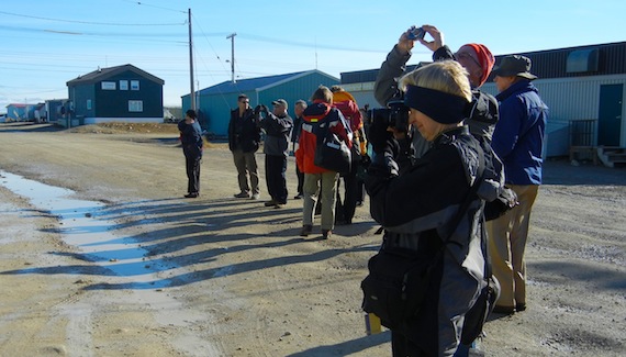Cruise ship passengers, with their cameras in hand, stand in the middle of the main street in Cambridge Bay during a stop in this western Nunavut community. (Jange George / Nunatsiaq News)