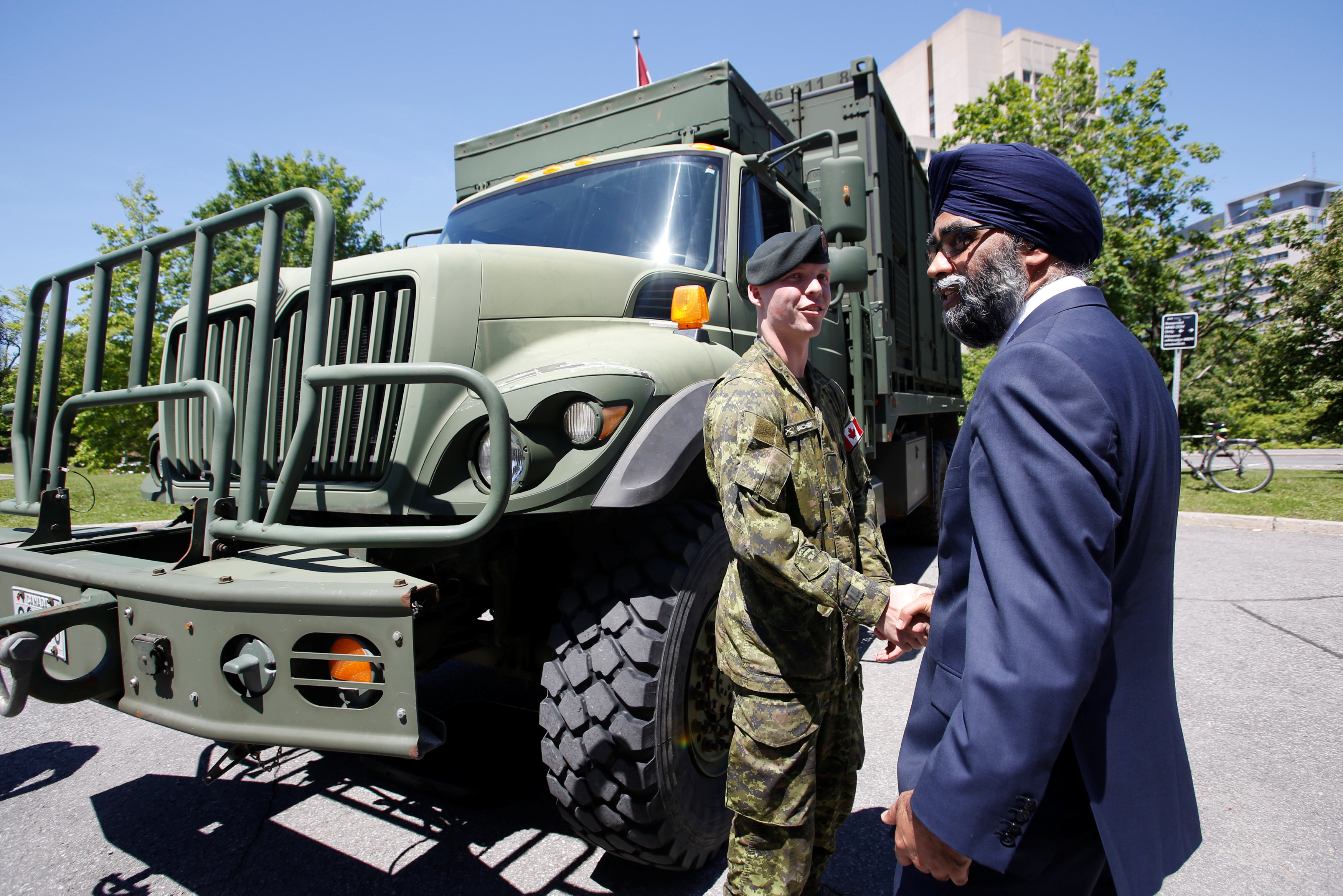 Canada's Defence Minister Harjit Sajjan (R) shakes hands with a Canadian Forces soldier after announcing Canada's new defence policy in Ottawa, Ontario, Canada, June 7, 2017. (Chris Wattie / Reuters)