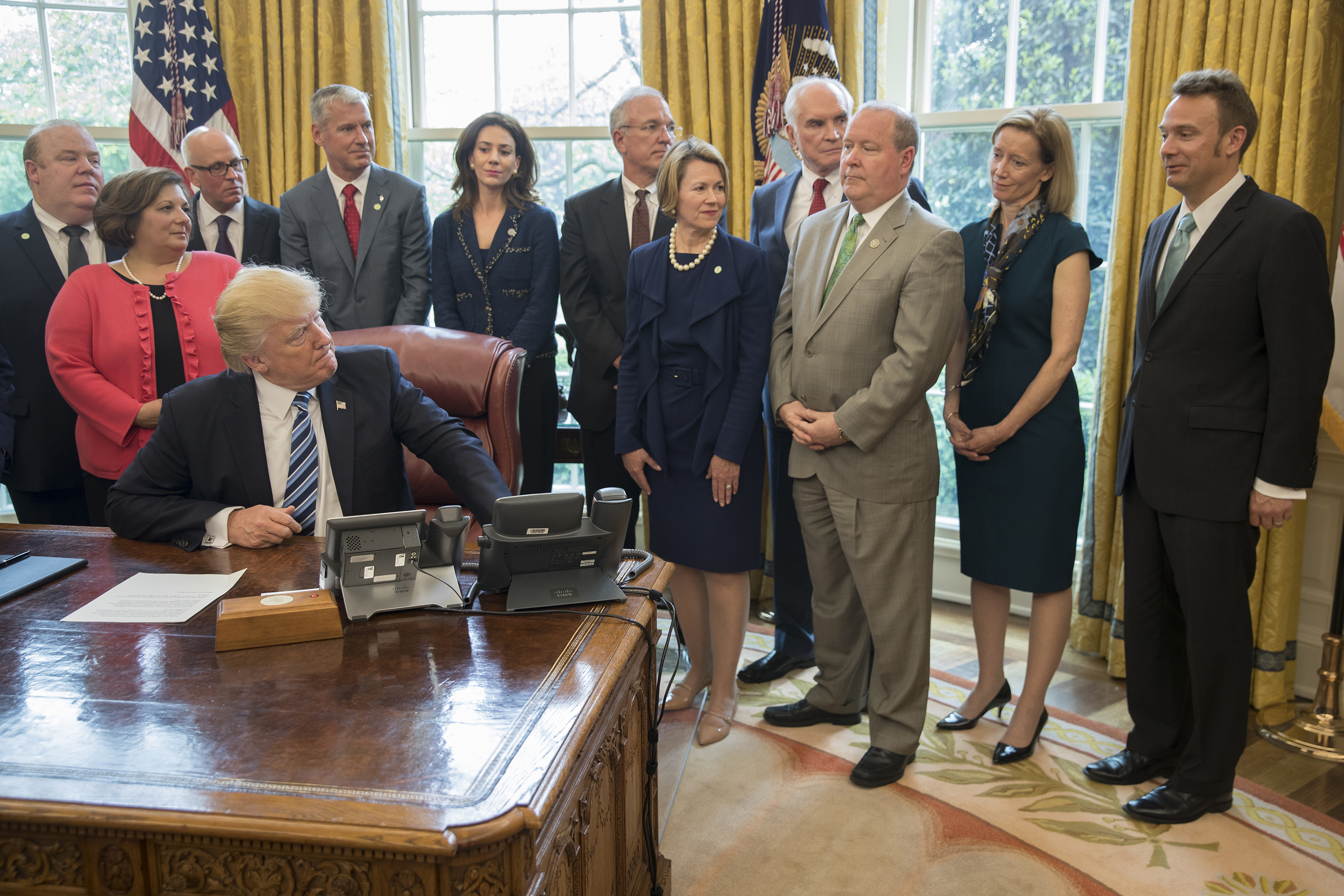President Donald Trump, flanked by members of Congress, and officials from the aluminum industry, signs a memorandum on aluminum imports and threats to national security, in Washington, April 27, 2017. The Trump administration blames China for the decline of aluminum production in the U.S., but some of America's largest aluminum companies, including Alcoa, operate in Iceland. At the right is Roy Harvey, chief executive officer of Alcoa Corporation. (Stephen Crowley/The New York Times)