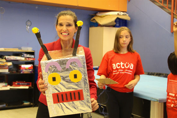 Sophia Mulak, 11, helps Science Minister Kirsty Duncan get through a coding exercise with this robot during Duncan's visit to Iqaluit July 21. (Beth Brown / Nunatsiaq News)