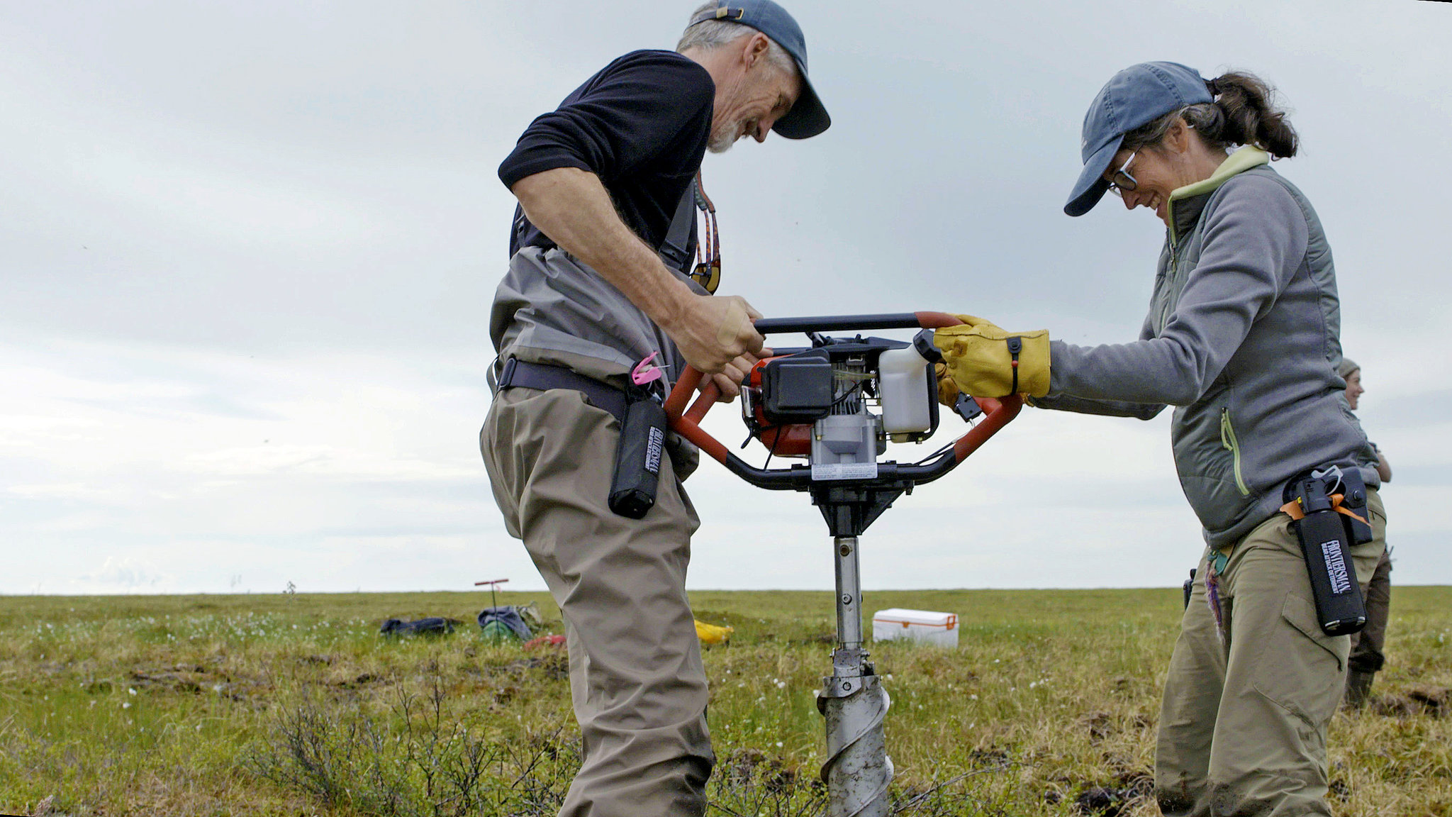 In an undated handout photo, Max Holmes and Sue Natali of the Woods Hole Research Center use an auger to drill core samples of permafrost in Alaska's vast Yukon Delta National Wildlife Refuge. The rate at which permafrost is thawing here is a vital question for climate scientists. "In order to know how much is lost, you have to know how much is there," Natali said. (Stash Wislocki via The New York Times)