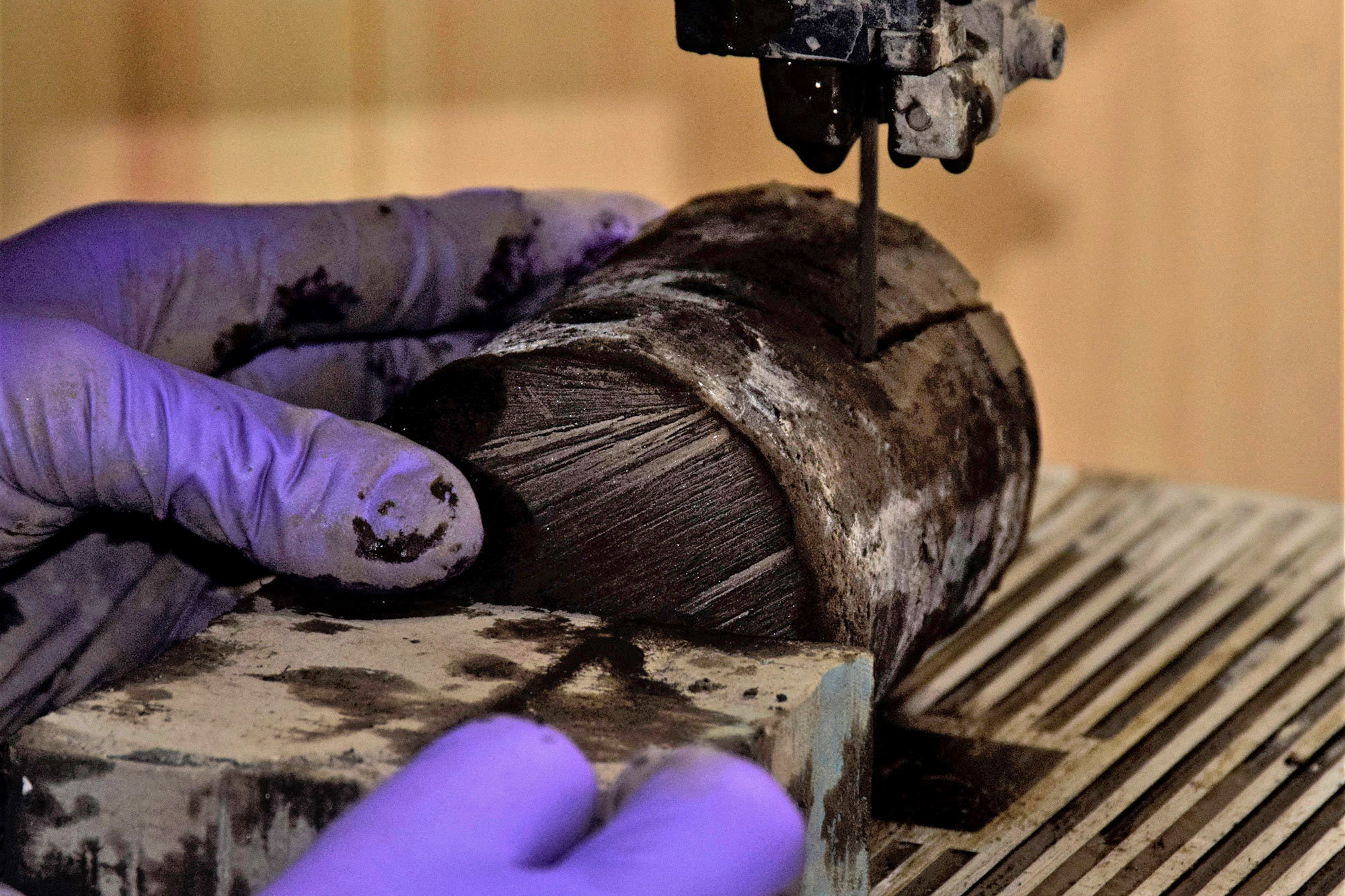 In an undated handout photo, Laura Jardine uses a saw to cut a core sample of permafrost taken from Alaska's vast Yukon Delta National Wildlife Refuge. The rate at which permafrost is thawing here is a vital question for climate scientists. (John Schade via The New York Times)