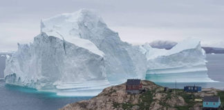 A huge iceberg has drifted close to a Greenland village, causing fears of a tsunami